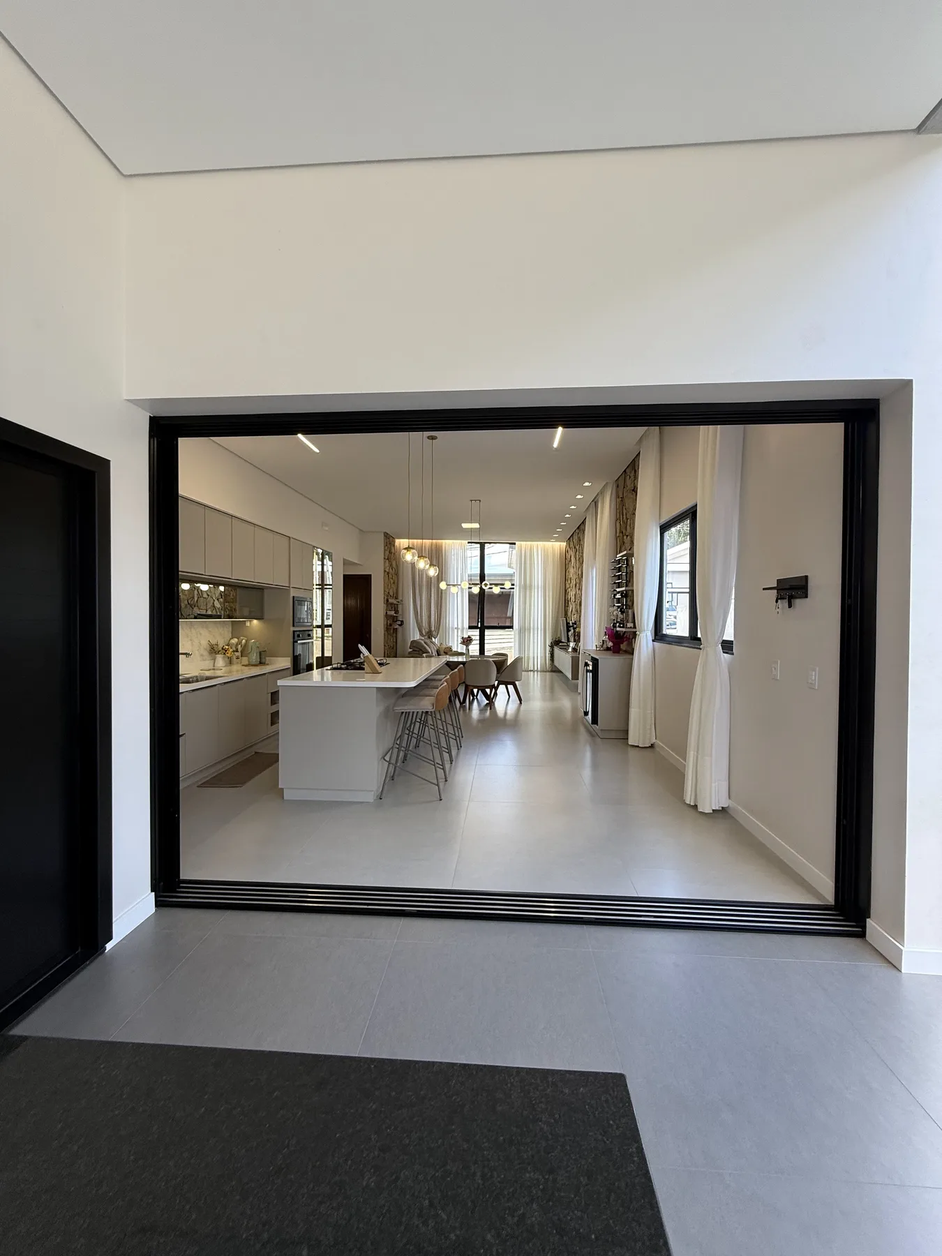 Grande vão de vidro integrando cozinha e sala